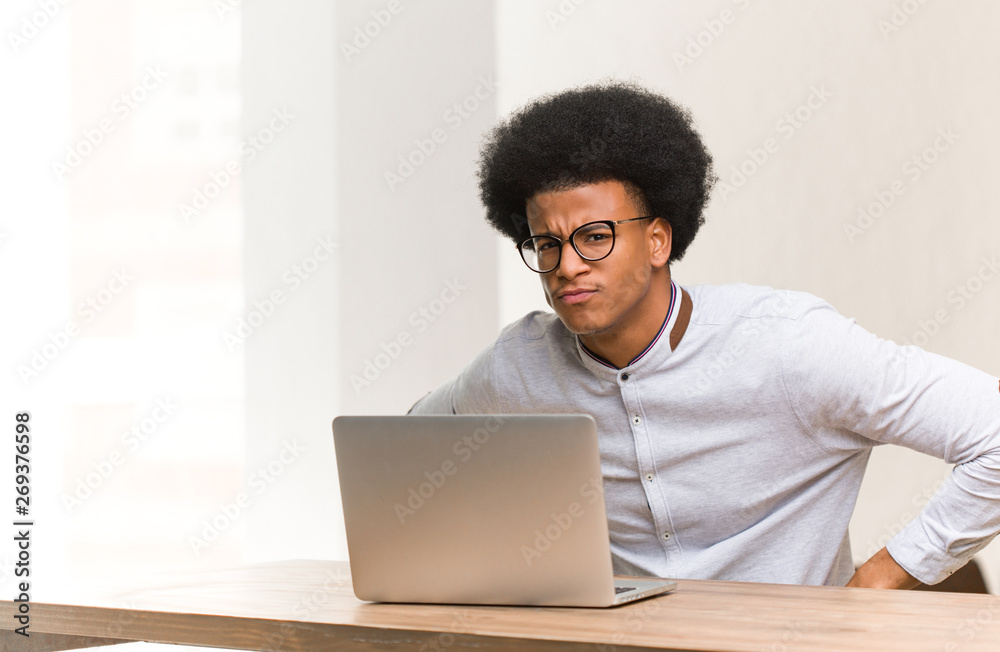 Young black man using his laptop scolding someone very angry Young black man using his laptop scolding someone very angry