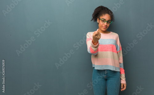 Young african american girl with blue eyes inviting to come