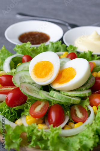 Healthy vegetables salad with boiled egg in wooden dish on table for vegetarian.