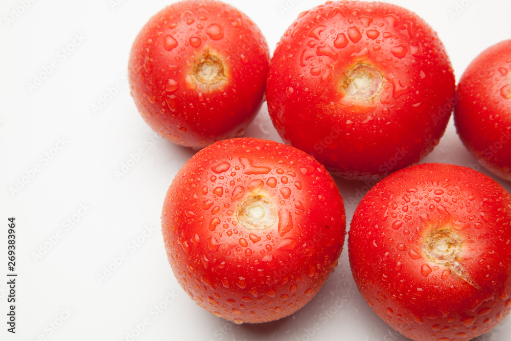 Tomate, rojo, sano con gotas de agua sobre fondo blanco Tomate, rojo, sano con gotas de agua sobre fondo blanco