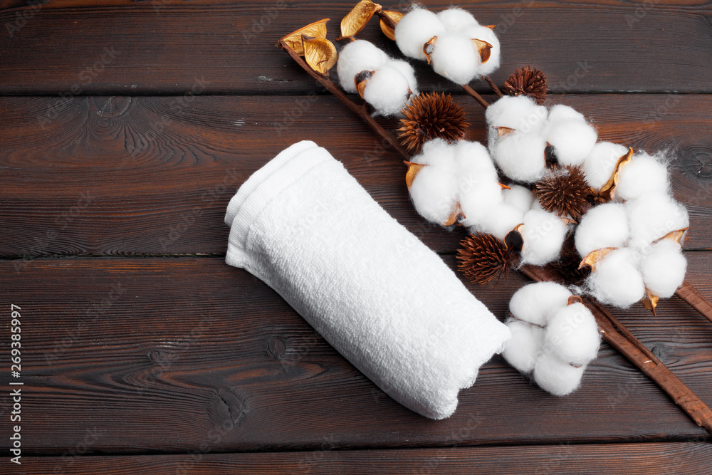 Cotton flowers with towel on wooden table Cotton flowers with towel on wooden table
