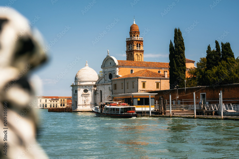 Vaporetto water bus station against San Michele in Isola church with tower in Laguna Nord, Venice