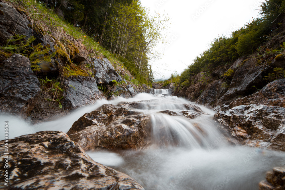 Waterfall in Logar Valley between snowy mountains forest in Spring vacation tourist, Logarska dolina, Slovenia Waterfall in Logar Valley between snowy mountains forest in Spring vacation tourist, Logarska dolina, Slovenia