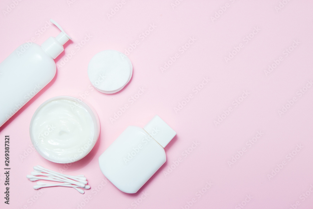 White jars of cosmetics on a pink background. Bath accessories. Face and body care concept White jars of cosmetics on a pink background. Bath accessories. Face and body care concept