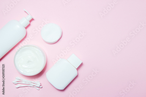 White jars of cosmetics on a pink background. Bath accessories. Face and body care concept