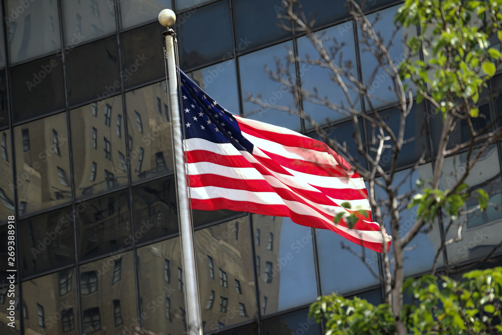 Amercian flag in dynamic motion - in front of a bank office building. US flag stock photo
