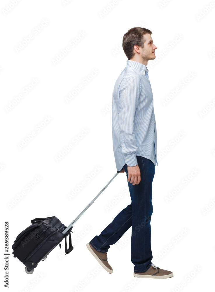 Side view of walking business man with suitcase talking on the phone.