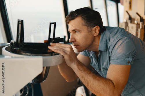 Marine deck officer taking magnetic compass error onboard of vessel at open sea. Job at sea