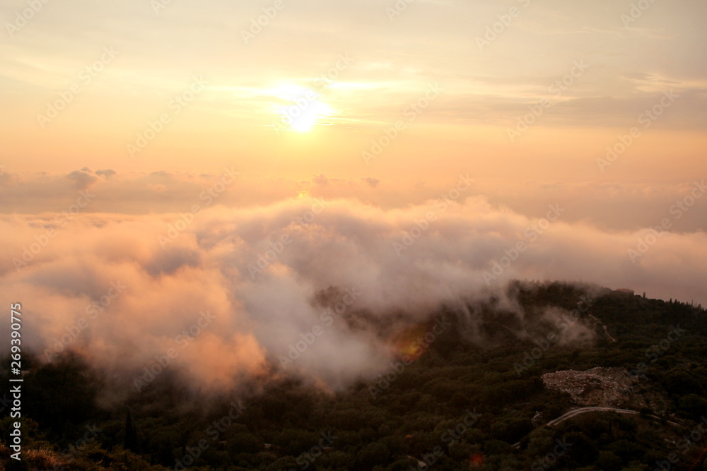 Obraz premium Beautiful structure of clouds on sky, mountain landscape with dense fog at sunset on horizon of beauty natural environment. Panorama of amazing sunrise view show sun rays through clouds over mountain.
