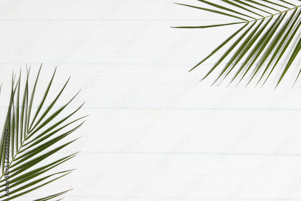 palm leaves on a wooden background with free space for text. a draft for a design. minimalism, creativity. flatlay - obrazy, fototapety, plakaty 