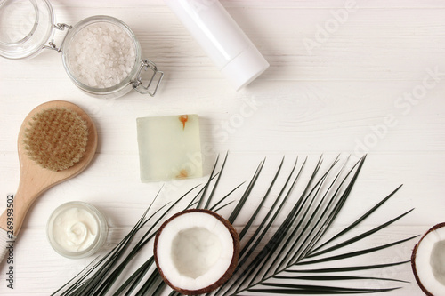 Coconut, tropical leaf and care products on a colored background top view. Cosmetics with coconut extract for hair, body, face. Skin care, skin hydration. flatlay