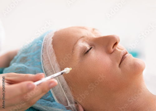 Beautiful woman having injections near eyes