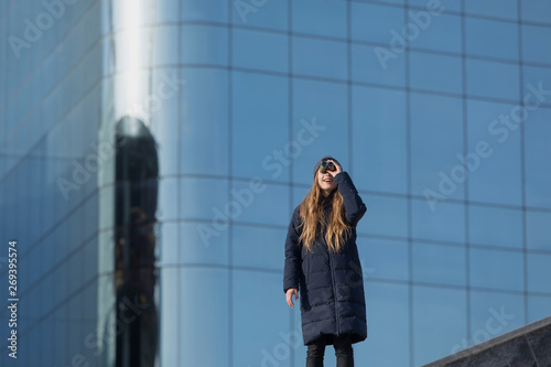 young woman looking at the binocular in front of the business building