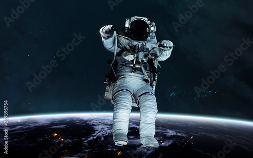 Fototapeta Naklejka Na Ścianę i Meble -  Astronaut at the Earth planet orbit. Awesome science fiction render. Elements of this image furnished by NASA