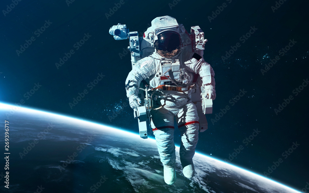 Fototapeta premium Astronaut at Earth orbit. Science fiction wallpaper. Elements of this image furnished by NASA