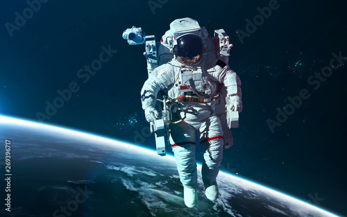 Fototapeta Naklejka Na Ścianę i Meble -  Astronaut at Earth orbit. Science fiction wallpaper. Elements of this image furnished by NASA