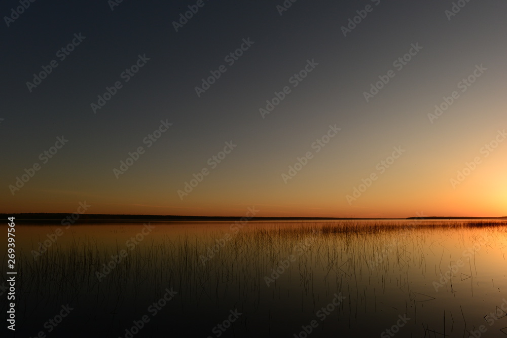 Spring cloudless blue sky over the lake in bright colors of sunset light and shadows Spring cloudless blue sky over the lake in bright colors of sunset light and shadows
