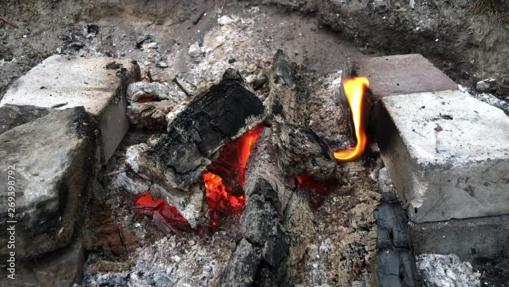 The fire is smoldering. Brick grill with burning coals. The fire burns and smoke comes out. The fire is smoldering. Brick grill with burning coals. The fire burns and smoke comes out.
