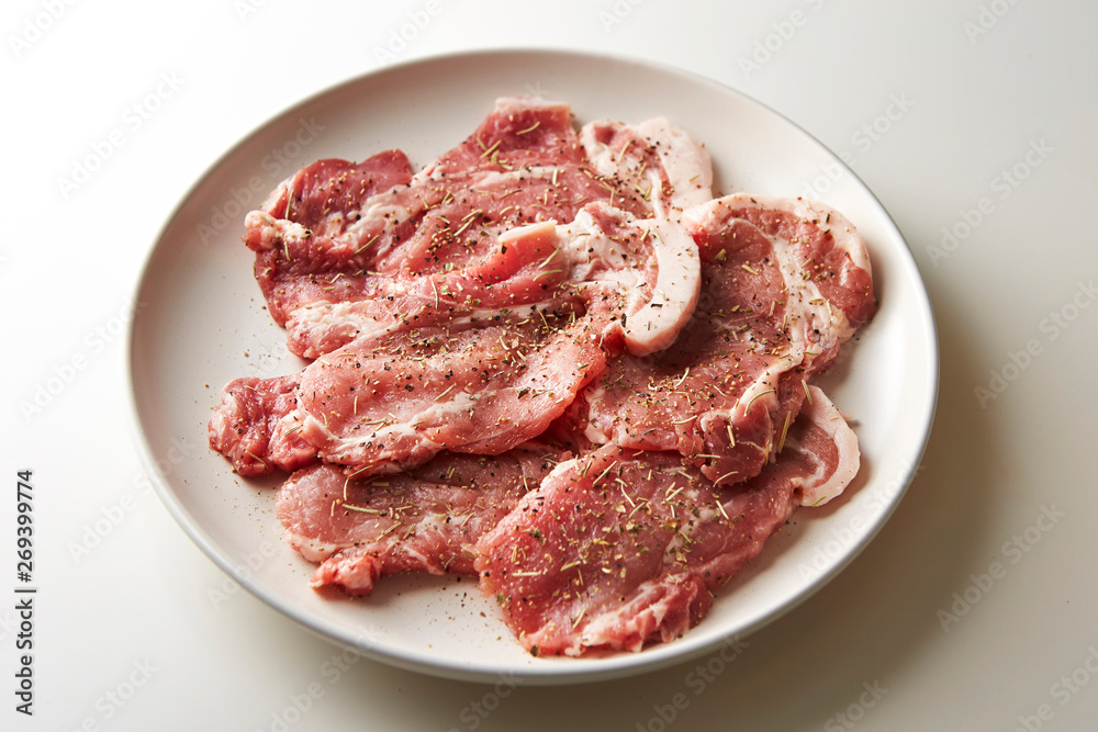 Fresh raw seasoned pork on plate Fresh raw seasoned pork on plate