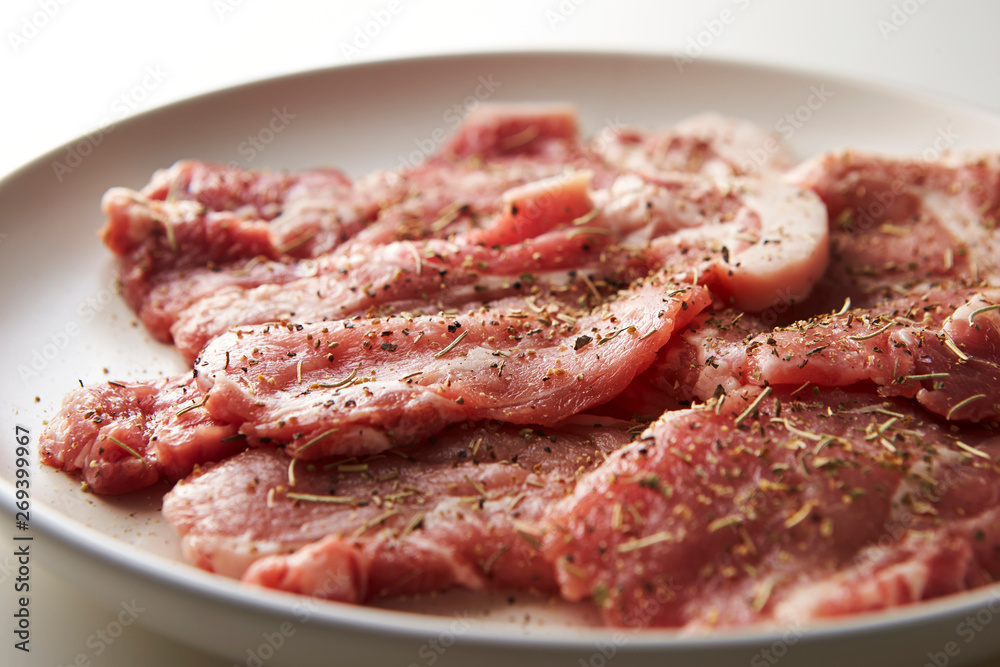 Fresh raw seasoned pork on plate 
