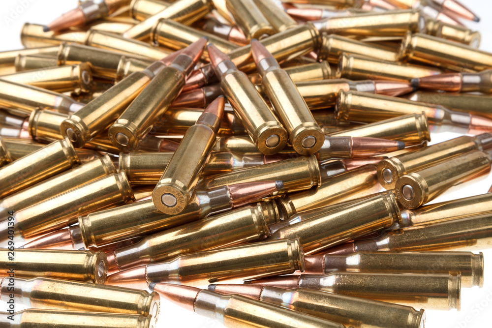cartridges for 308 caliber rifle on a white background. a bunch of ammo. cartridges scattered on a light background cartridges for 308 caliber rifle on a white background. a bunch of ammo. cartridges scattered on a light background