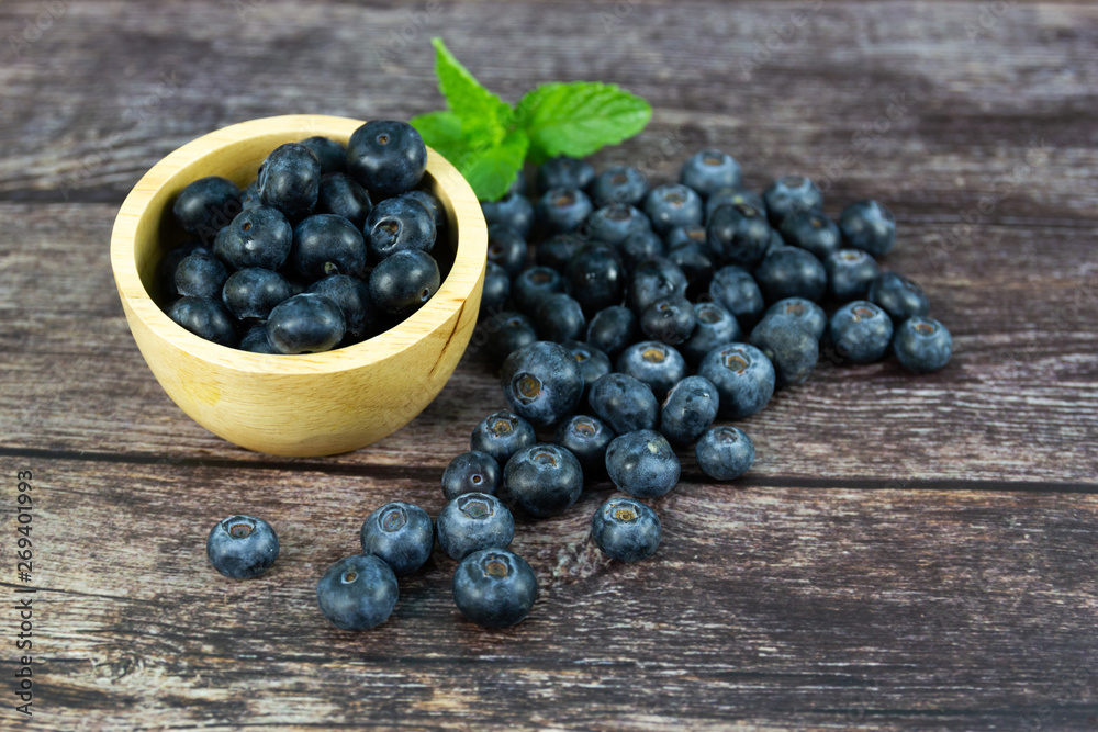 Fresh blueberries in a wooden bowl on wood table Fresh blueberries in a wooden bowl on wood table