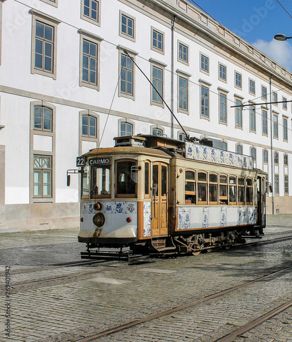 View of tram in Porto, with historical Portuguese building behind.