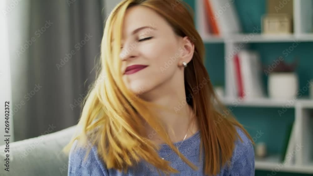 Portrait of a young cheerful girl in her cozy living room