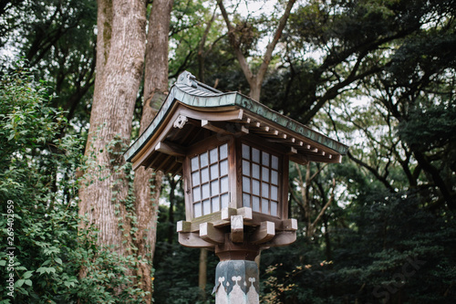 Japanese style wooden lantern With trees on background  in Meiji Shrine, Shibuya, Japan. © NETFILEOS