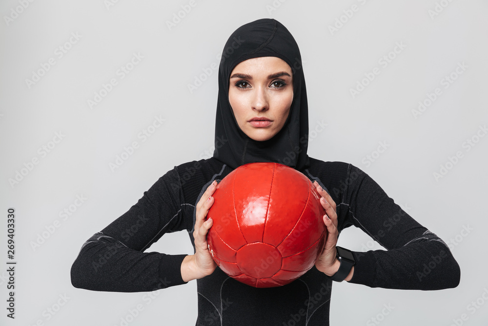 Woman fitness muslim posing isolated over white wall background make exercises with ball. Woman fitness muslim posing isolated over white wall background make exercises with ball.