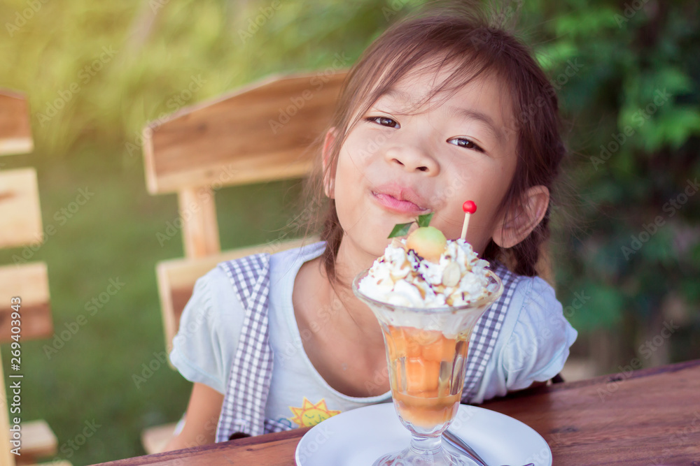 Asian children girl are happy to eating cantaloupe ice cream. in thailand Asian children girl are happy to eating cantaloupe ice cream. in thailand