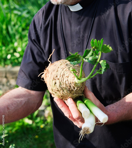 clergyman - vicar or priest - exchanging money for vegetables at a market
