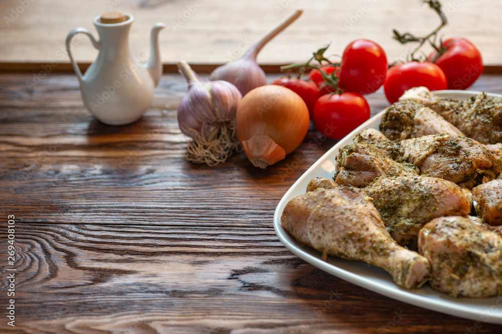 Raw chicken legs with herbs and spices on white dish. Raw chicken legs with herbs and spices on white dish.
