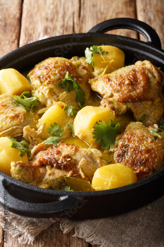 Asian chicken coconut curry with potatoes close-up in a pan. vertical