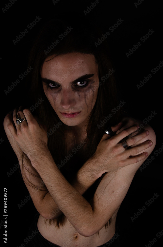 Photo of a man with long hair. Hands like a straitjacket.