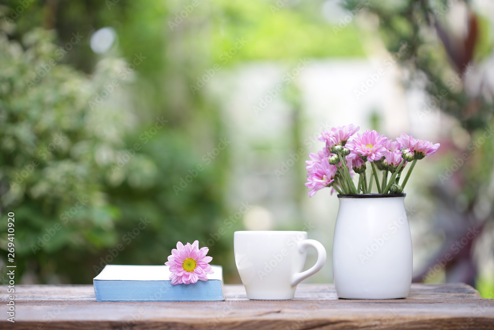 white coffee cup with flower pot and notebook on wooden table
