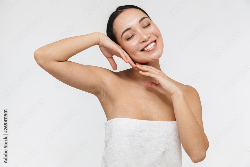 Obraz premium Portrait of relaxed half naked asian woman touching her clear skin and smiling