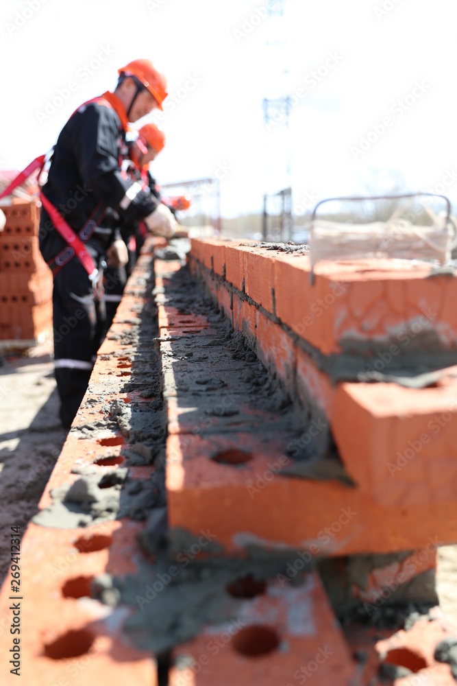 Brick laying Workers laid brick. Smooth brick laying. Red brick construction