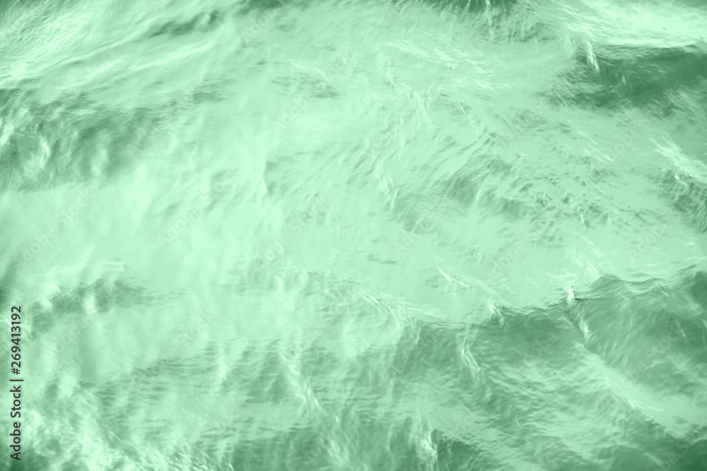Obraz premium Closeup of calm river water surface with water splashes in neo mint color. Ideal river, sea and ocean texture. Trendy fresh abstract nature background. Color of the year 2020