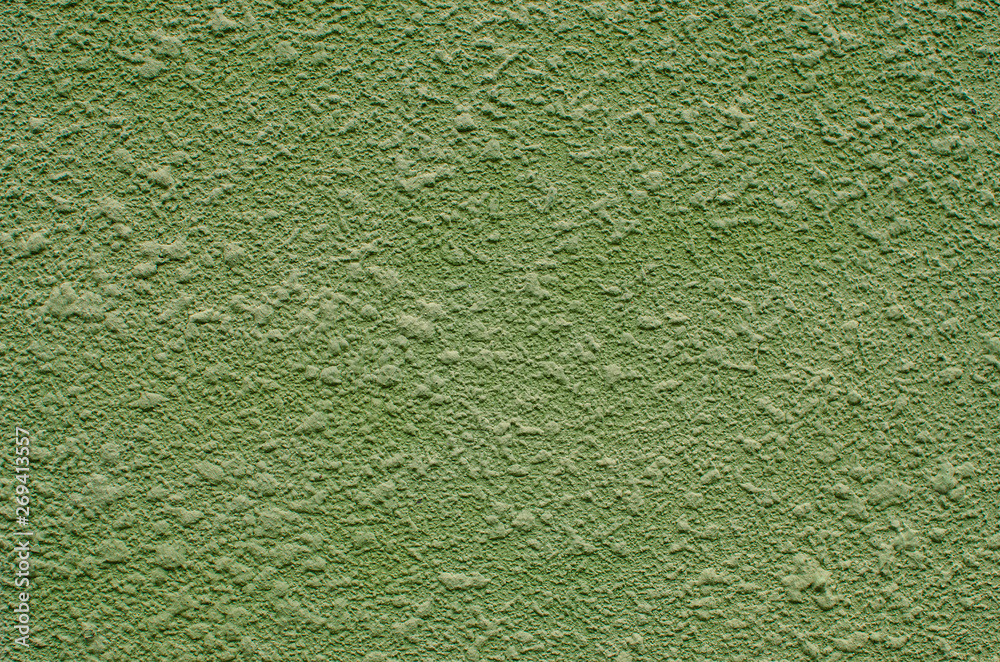 Background, texture of a modern plastered facade of a residential building. External facing of walls by machine plaster of green color.