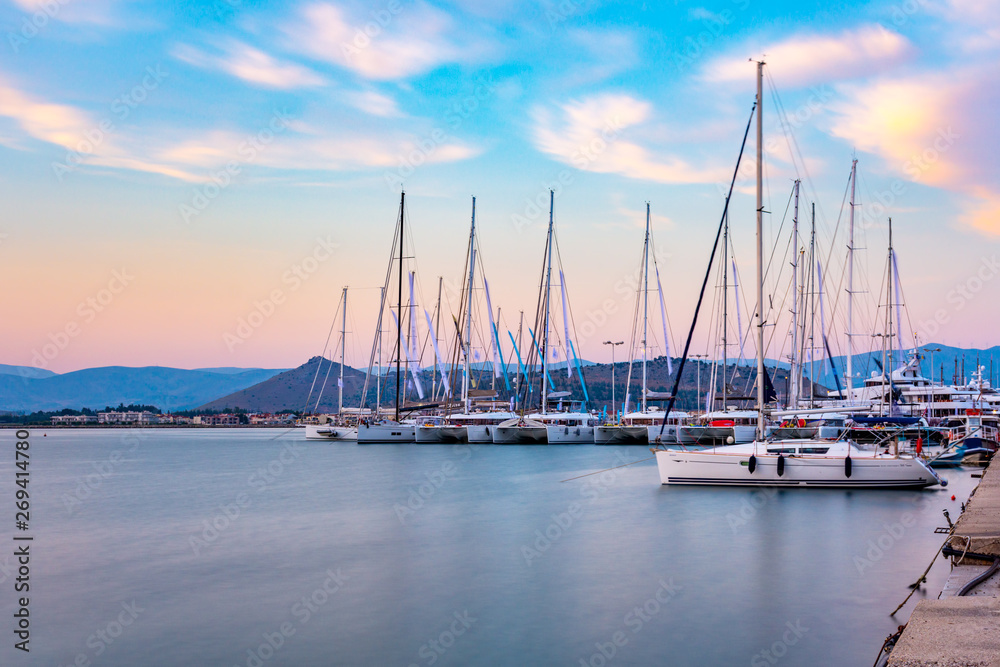 Luxury yachts docked in sea port at sunset