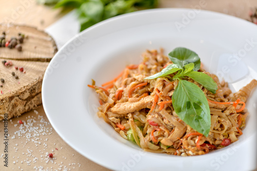 pasta with chicken and vegetables decorated with basil