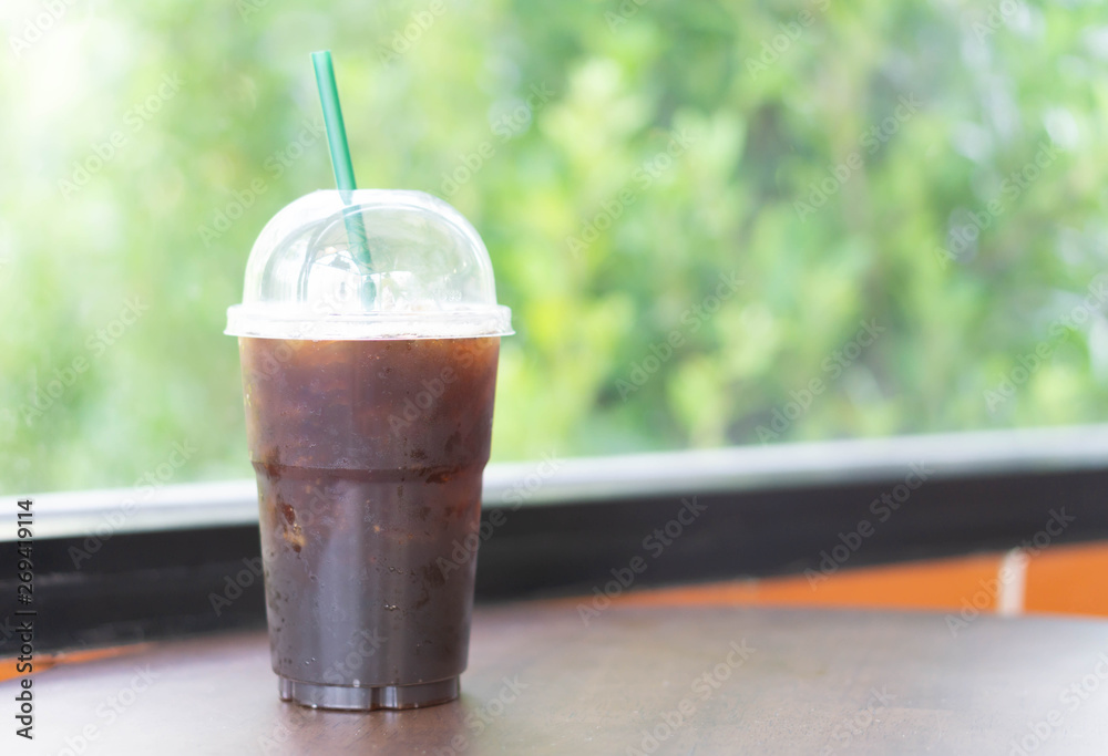 Close up glass of ice americano coffee on wood table in coffee shop, selective focus Close up glass of ice americano coffee on wood table in coffee shop, selective focus