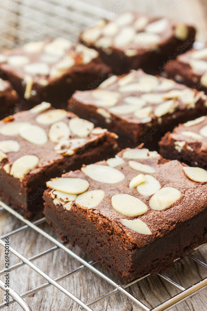 Closeup homemade brownies sliced on baking rack over wooden table. Sweet dessert for chocolate lover.