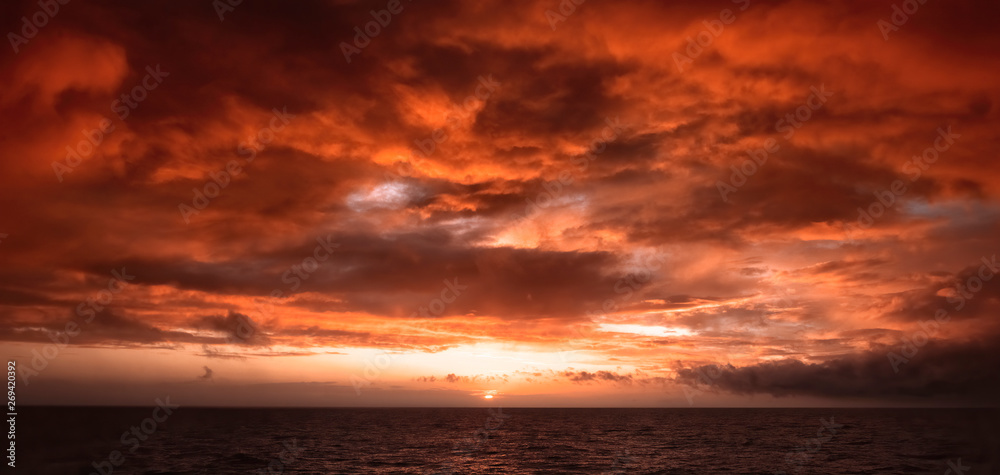 Dramatic Fiery Sunset With Orange And Red Clouds Over The Ocean
