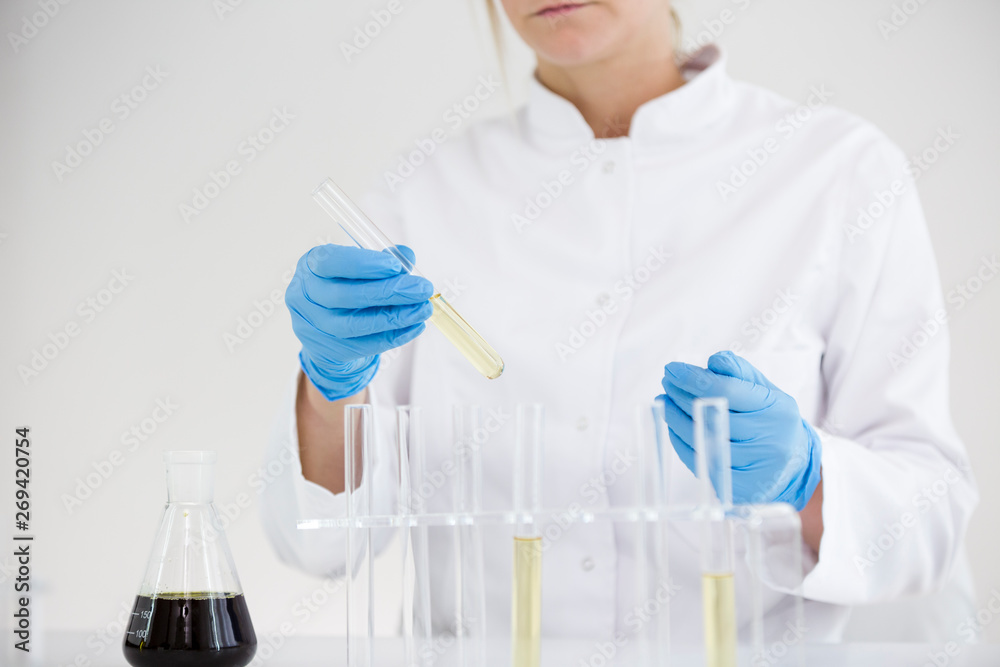 Scientist tearing the CBD oil from one tube into another Scientist tearing the CBD oil from one tube into another