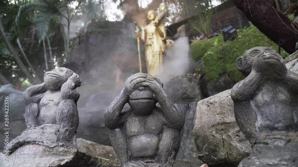 hree wise monkeys at golden mount temple Thailand, Bangkok. See no evil, hear no evil, speak no evil statues in exterior, outside shrine with flowing misty water features. hree wise monkeys at golden mount temple Thailand, Bangkok. See no evil, hear no evil, speak no evil statues in exterior, outside shrine with flowing misty water features.