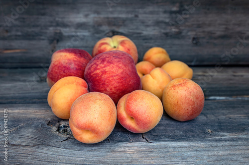 Ripe fruits of peaches and apricots close up on a wooden board