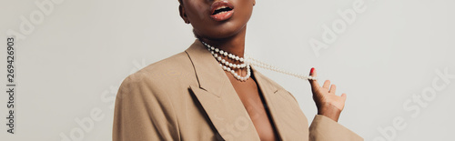 Fotografija cropped view of seductive african american woman in beige jacket and necklace is