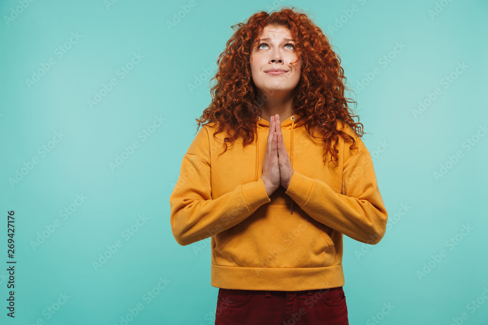 Image of gorgeous woman 20s with curly ginger hair keeping palms together and praying for good luck Image of gorgeous woman 20s with curly ginger hair keeping palms together and praying for good luck